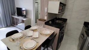 Una cucina moderna con zona pranzo, televisione e forno a microonde.