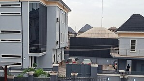 Una zona residencial con casas modernas, un acceso con portón y cielo despejado.