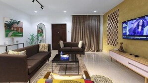 Una sala de estar moderna con un sofá, una mesa de centro y una televisión.