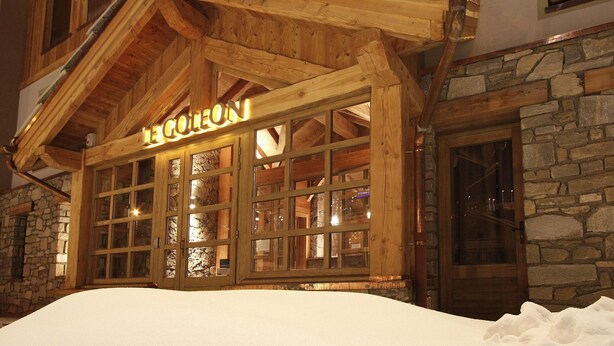 A wooden lodge with a stone facade, large windows, and a snow-covered ground. - Spacious Alpine Apartment by the Chairlifts (Les Deux Alpes)