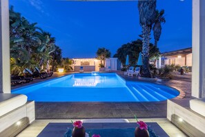 A swimming pool with lounge chairs and a well-lit patio area. - Seaside Gallipoli Modern Villa for 8 (Gallipoli)