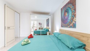 Een slaapkamer met een bed, een spiegel en een schilderij.