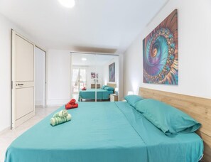 Ein Schlafzimmer mit einem Bett, einem Spiegel und einem Gemälde.