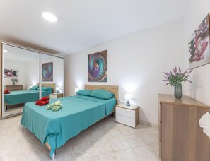 A bedroom with a bed, bedside tables, a mirror, and artwork on the walls. - Seaside Gallipoli Modern Villa for 8 (Gallipoli)