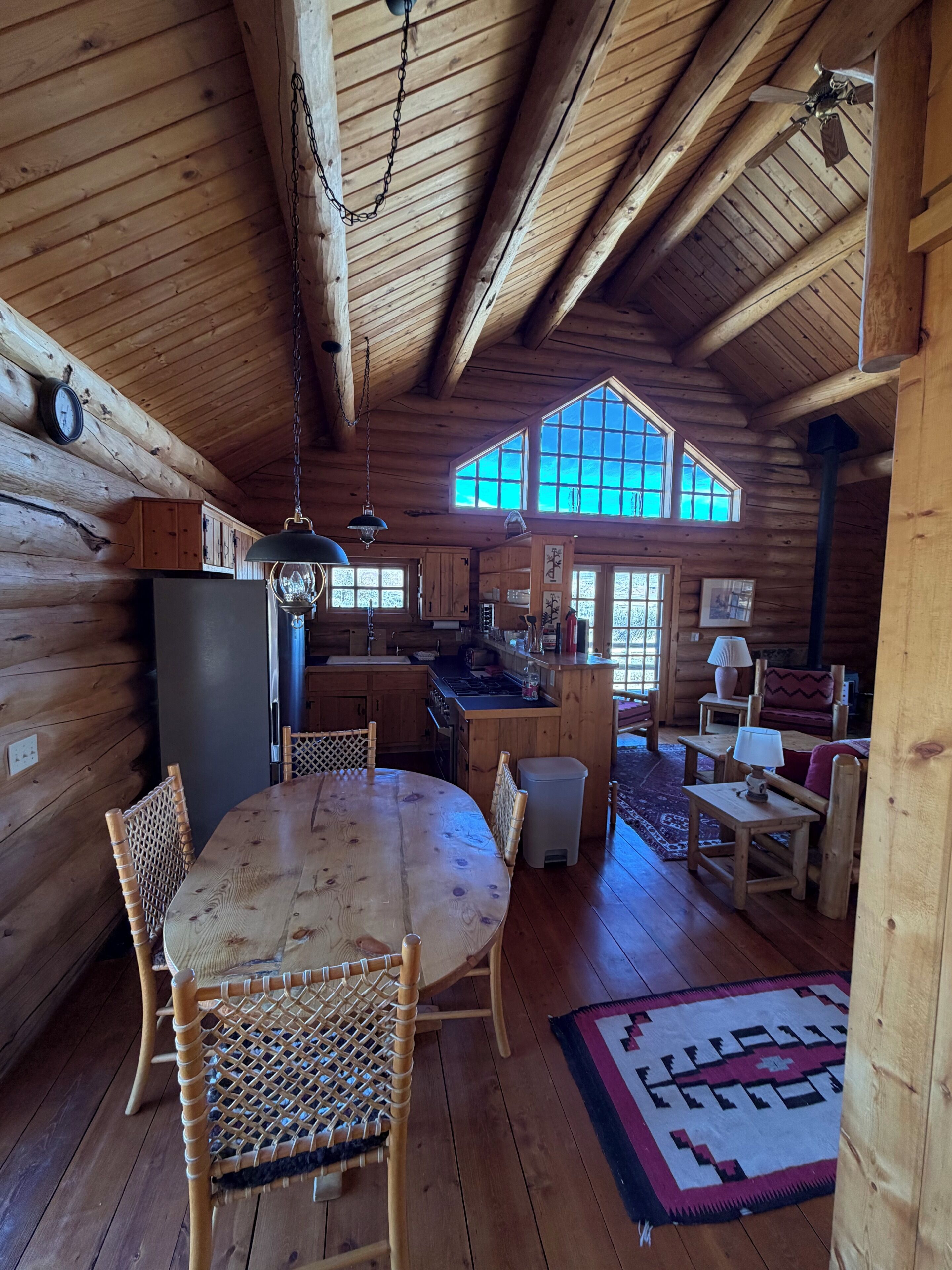 L’intérieur d’une cabane en rondins comprend un coin repas, une cuisine et un espace de vie.