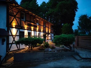 Un edificio tradizionale a graticcio con una facciata ben illuminata e un giardino curato.