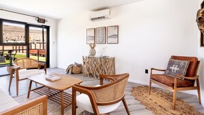 Ein modernes Wohnzimmer mit großem Fenster, Essbereich und einer Sitzecke.
