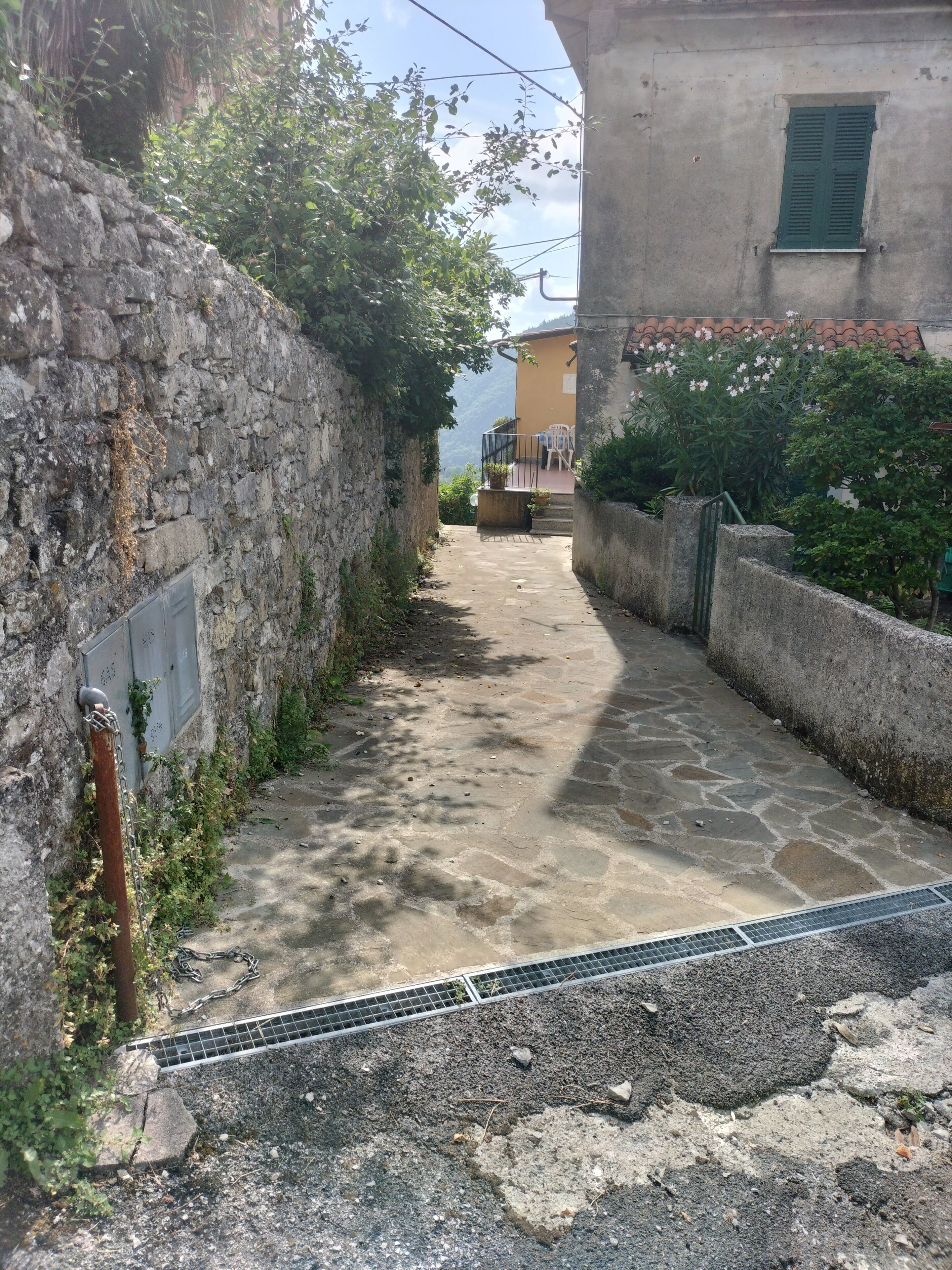 Un estrecho sendero de piedra que lleva a un edificio con balcón.