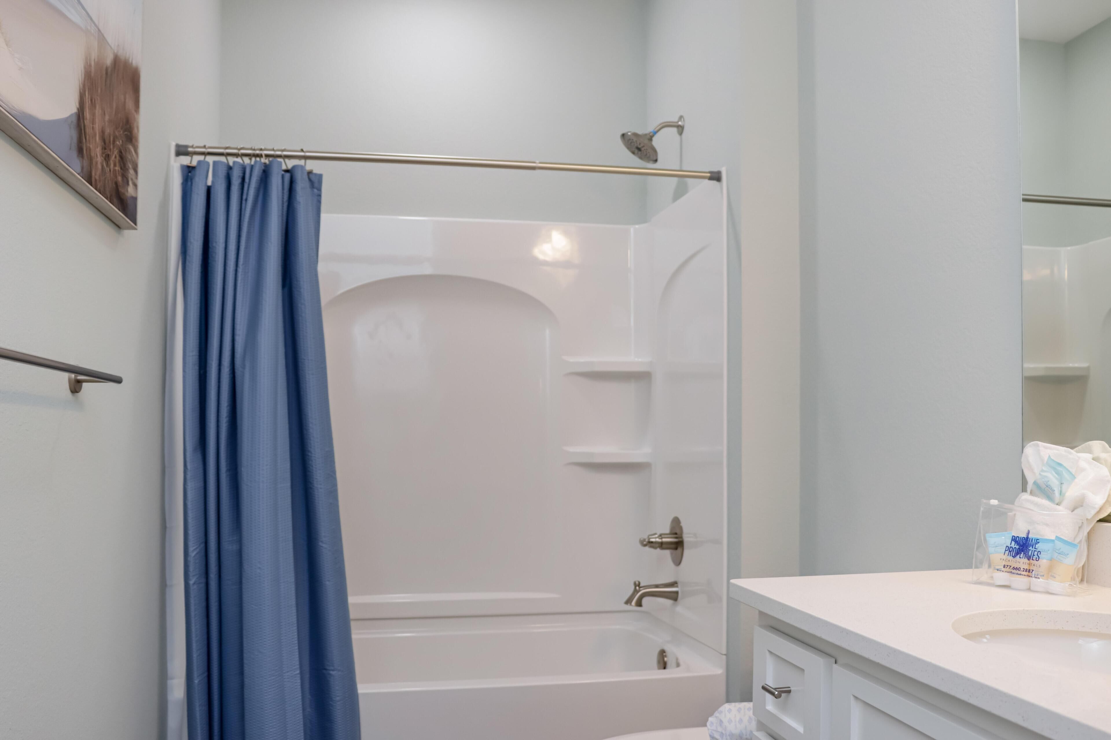 Ein Badezimmer mit Dusche, Toilette, Waschbecken und Spiegel.