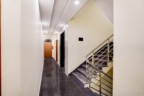 A corridor with a staircase, a door, and a fire extinguisher.