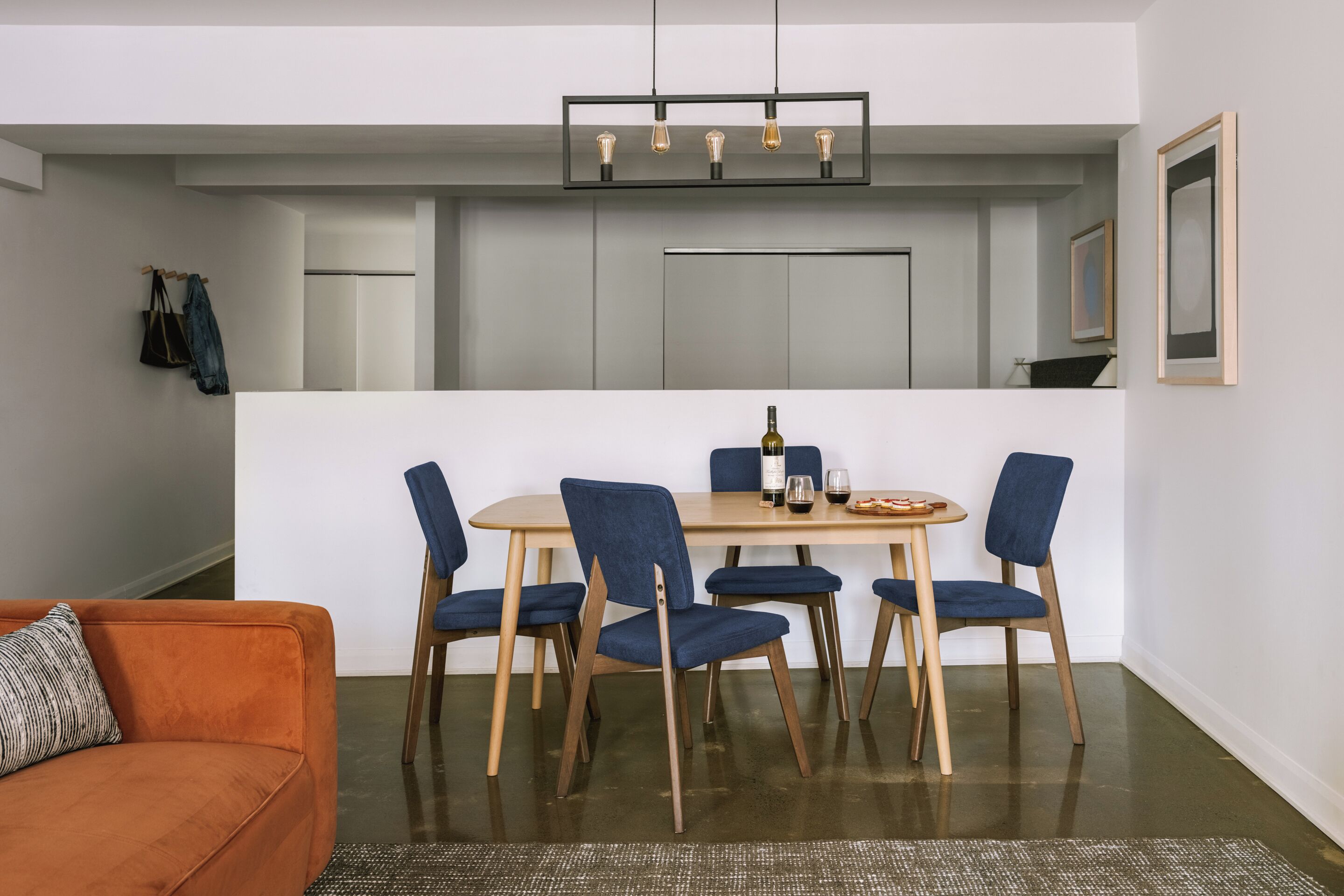 A compact living space with a dining area, a sofa, and a kitchen.