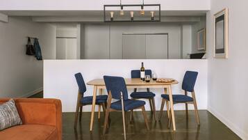 A compact living space with a dining area, a sofa, and a kitchen.