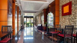 A hotel lobby with a reception desk, seating area, and a staircase leading to another floor. - Dinan Stay With Free Parking (Dinan)