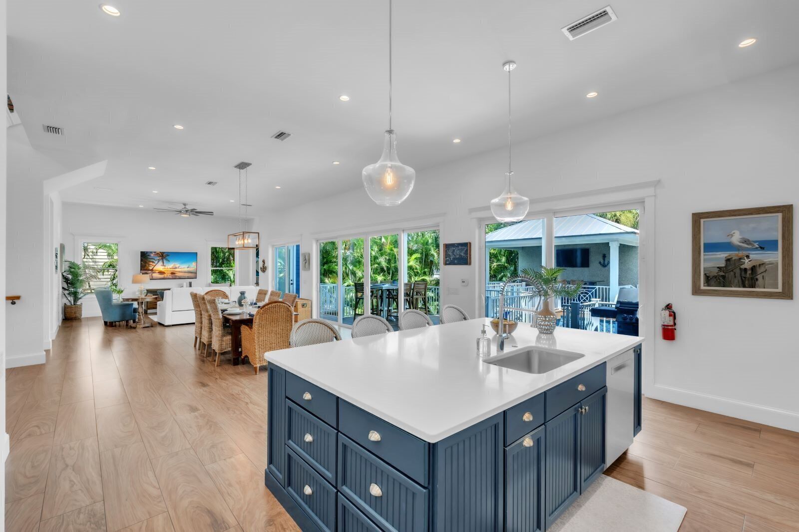Una cocina amplia con una isla grande, iluminación colgante y vistas al exterior.