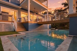 A residential property with a swimming pool, a covered outdoor area, and a staircase leading to a balcony. - Slice of Paradise by Duncan Real Estate (Holmes Beach)