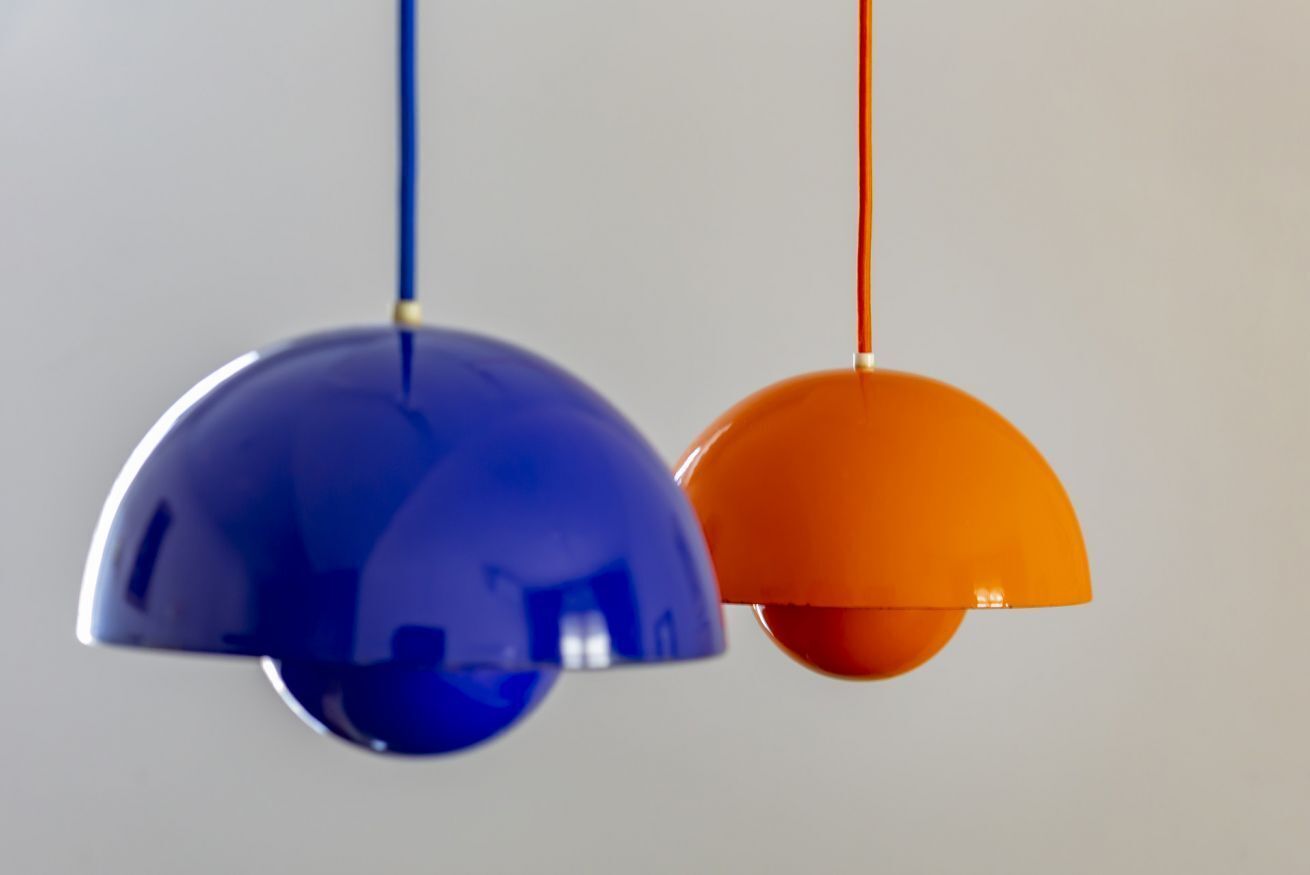 Two pendant lights with a blue and an orange shade.