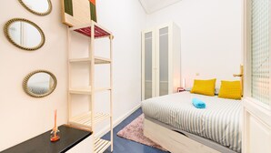 Une chambre à coucher comprenant un lit, une armoire, une étagère et un miroir.