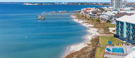 A coastal hotel with a swimming pool, beach access, and a view of the ocean.