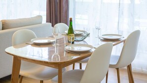A dining table with chairs, a bottle of champagne, and wine glasses. - Apartment “Ty Heol – Balcony and Near Center” with Balcony and Wi-Fi (Quimper)