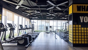 Academia com esteiras, bicicletas ergométricas e equipamentos de musculação.