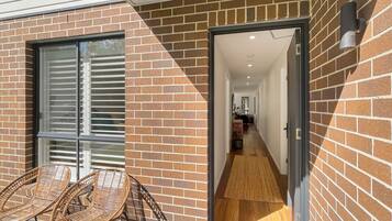 A brick exterior with a glass door leading to a hallway.