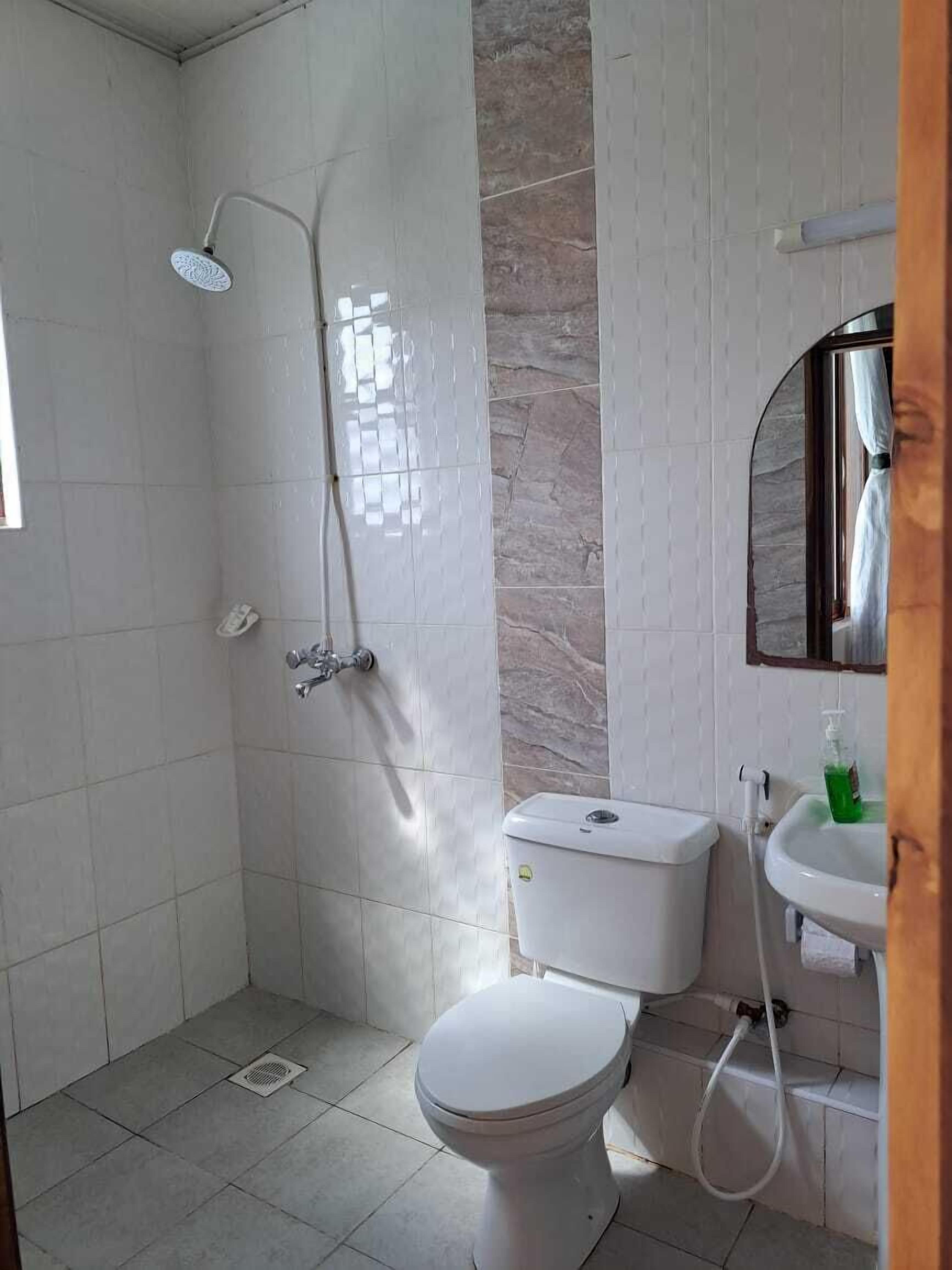 A bathroom with a shower, toilet, and sink.