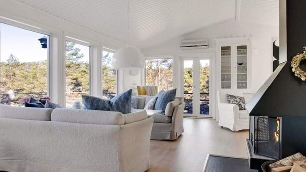 Un espacio habitable amplio con chimenea, ventanas grandes y vistas al exterior.