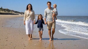 Una famiglia che cammina su una spiaggia sotto un cielo sereno.