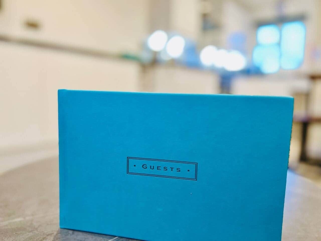 Une boîte bleue sur laquelle est écrit le mot « INVITÉS ».