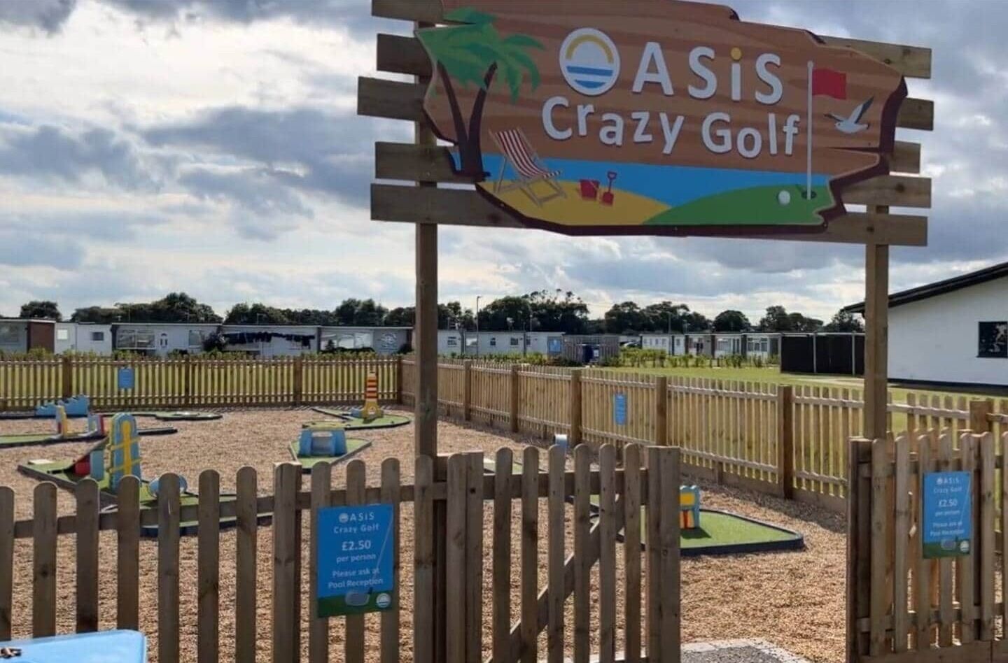 Señal de madera para Crazy Golf ASIS con un letrero de recepción de piscina debajo.