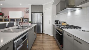 Una cocina moderna con electrodomésticos de acero inoxidable, lavavajillas y horno empotrado.