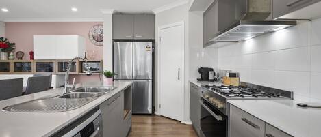 A modern kitchen with stainless steel appliances, a dishwasher, and a built-in oven.