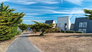A residential area with modern houses, a paved path, and a clear sky. - Apartment With Terrace Near Sea (Guidel)