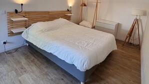 A bedroom with a bed, bedside lamps, a hanging light fixture, and a tripod lamp. - Ideal stay in Le Croisic (Le Croisic)