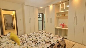 Une chambre à coucher avec un lit, un miroir et une armoire.