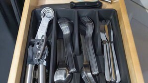 Un tiroir contenant des ustensiles de cuisine, notamment un fouet, un embout pour fouet et une spatule.