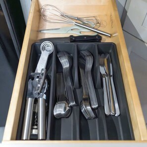 A drawer with kitchen utensils including a whisk, whisk attachment, and a spatula. - Stylish Center City Studio | By Rafa Properties (Philadelphia)