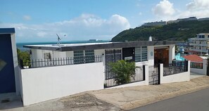 A modern building with a flat roof, a small balcony, and a gate. - The Biolume Retreat (Las Croabas)