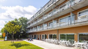 Ein mehrstöckiges Gebäude mit Balkonen, Außenbereich und einem Spielplatz.