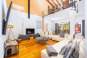 Ein modernes Wohnzimmer mit Kamin, Sofa, Couchtisch und Fernseher.
