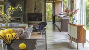 A modern living room with a fireplace, seating area, and a view of the outdoors.