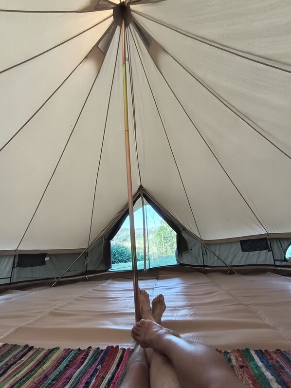 A tent with a peaked roof, a central pole, and a view of greenery outside. - Astial Ezquerra Experience – Charming Nature Retreat (Villagalijo)