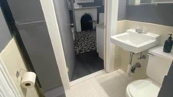 Ein Badezimmer mit Toilette, Waschbecken und Duschbereich.
