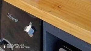 Et tekøkken med kaffemaskine, et knivdisplay og glas på en hylde.