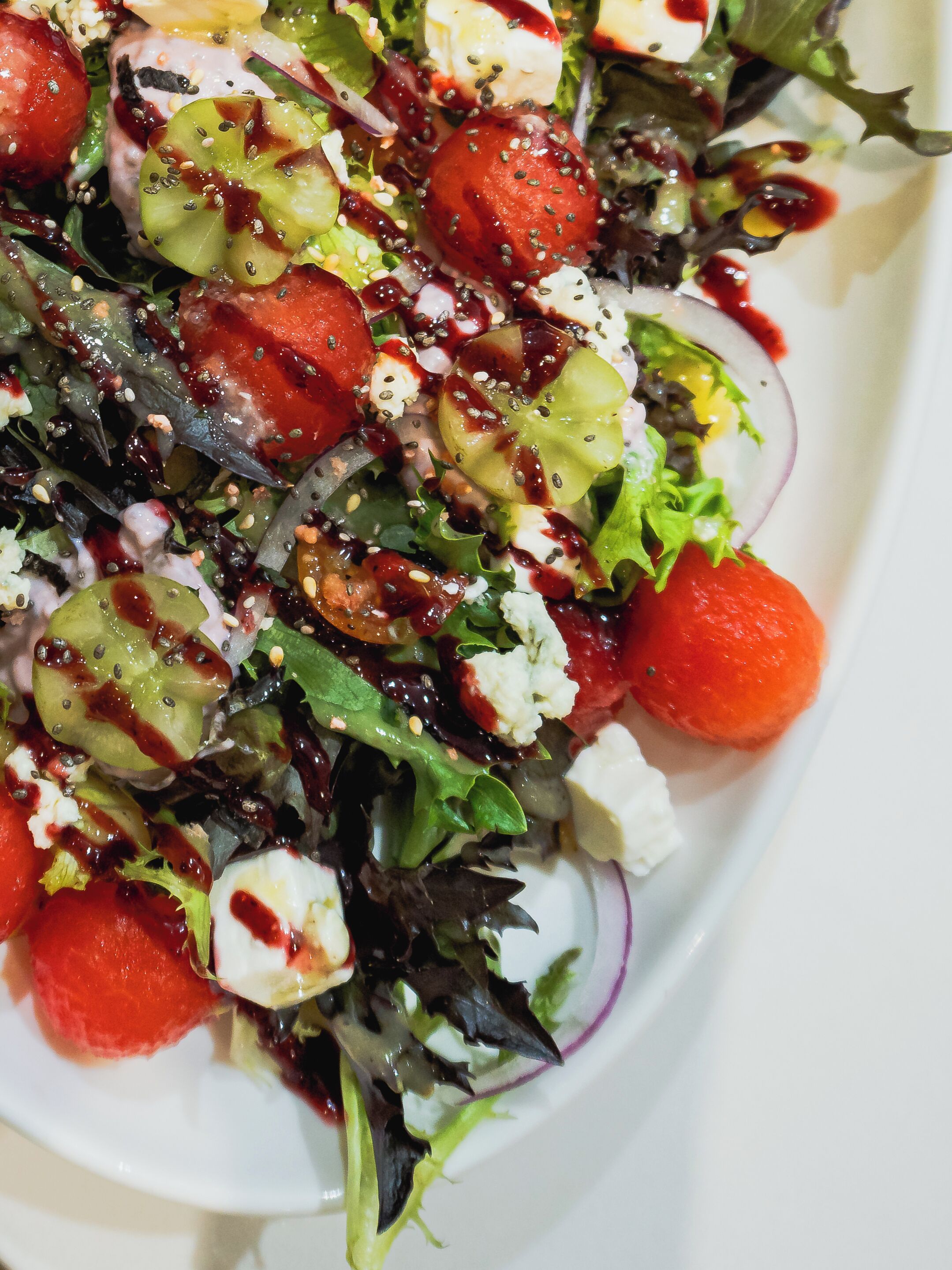 A salad with various ingredients and a white plate.