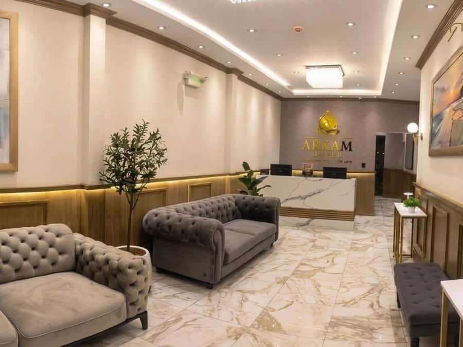 Un vestíbulo de hotel con una recepción, zona de estar con sofás y obras de arte en las paredes.