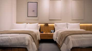 Una habitación de hotel con dos camas, una mesita de noche con lámpara, un cuadro en la pared y un reloj.