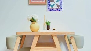 Une table en bois sur laquelle sont posés un vase de fleurs et une petite plante.