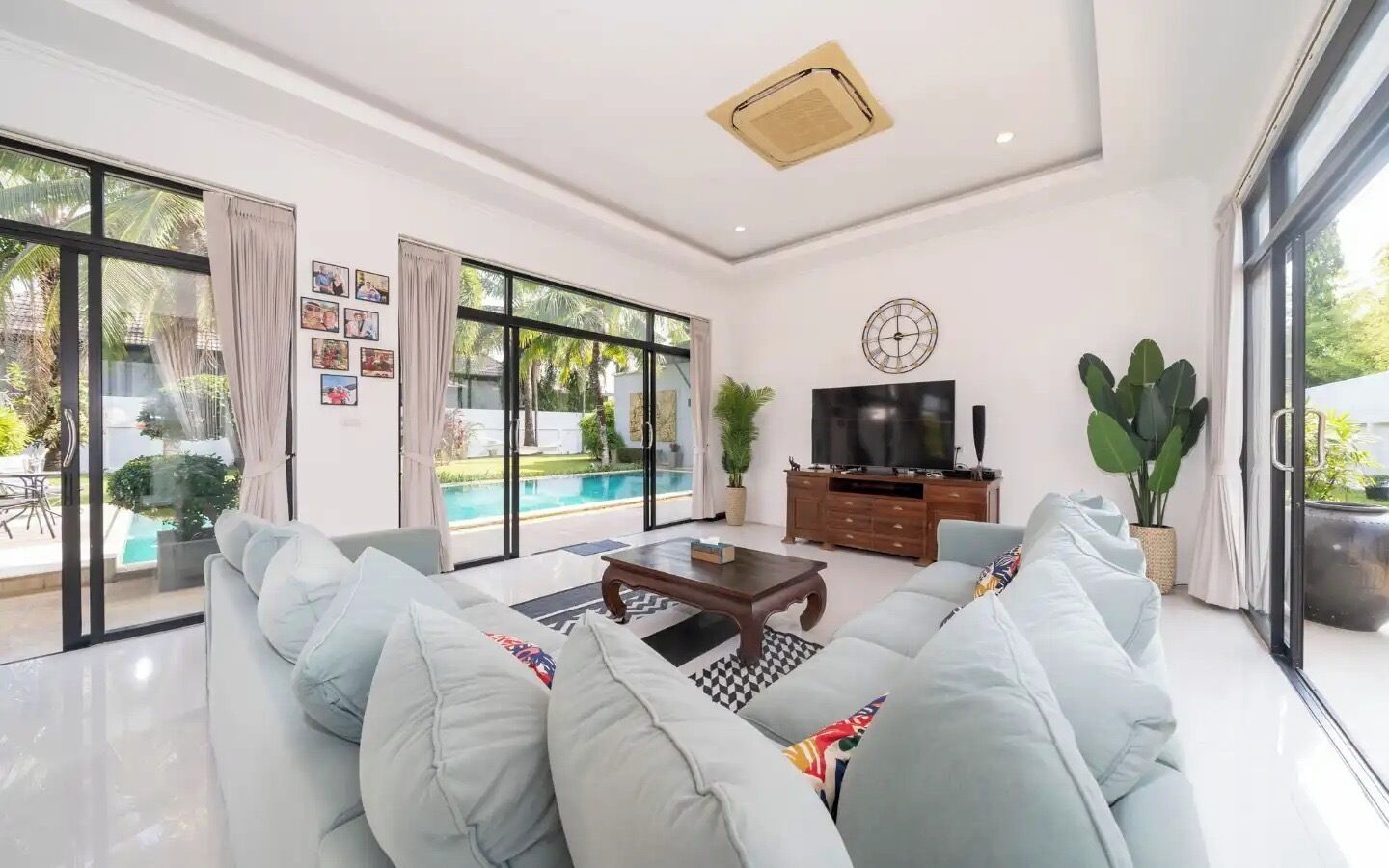 A modern living room with a large sofa, a coffee table, and a TV.