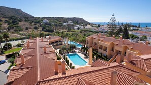 A resort with terracotta-tiled roofs, a swimming pool, and a view of the sea. - Sky Light Bay (Luz)
